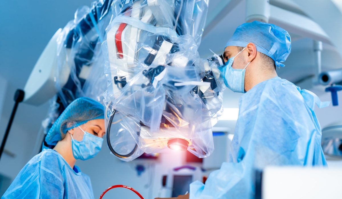 Team of surgeons operating in the hospital. Modern equipment in operating room. Medical devices for neurosurgery.